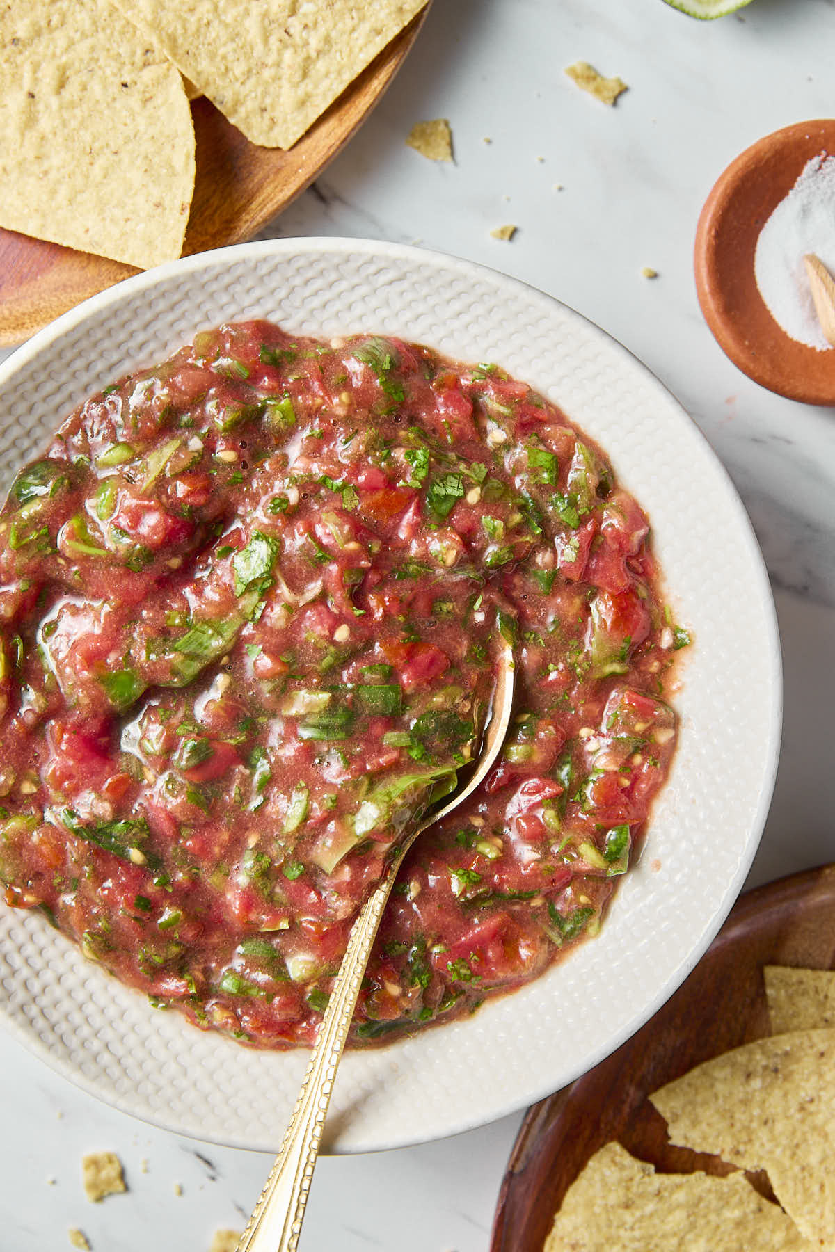 Cherry tomato salsa in a white serving bowl with a metal spoon.
