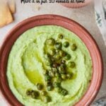 Text overlay on a pin showing "Healthy Green Pea Easy Hummus" with a photo of green pea hummus in a bowl, garnished with roasted peas and olive oil drizzle.